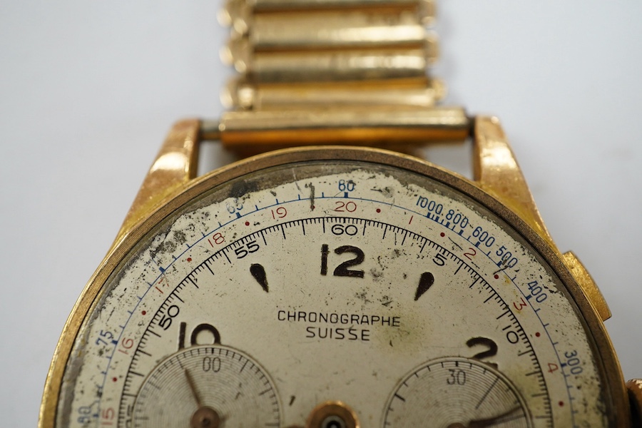 A gentleman's yellow metal Swiss chronograph manual wind wrist watch (lacking back cover), on a gold plated strap. Condition - poor.